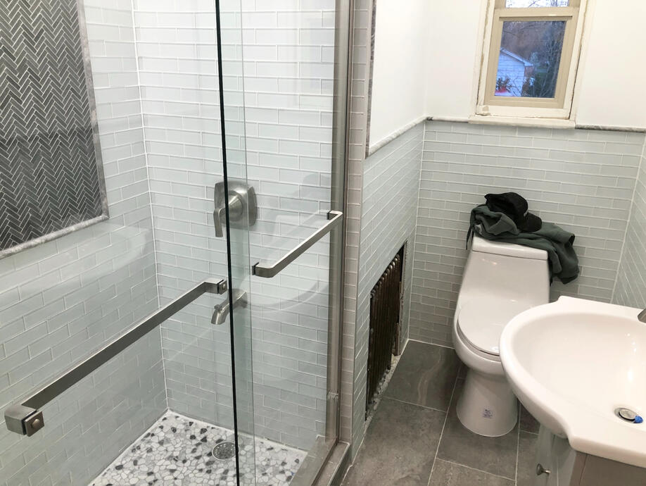 After image with all new tiles, shower glass, and vanity