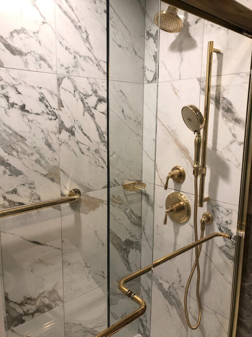 Marble tilework and brass shower fixtures